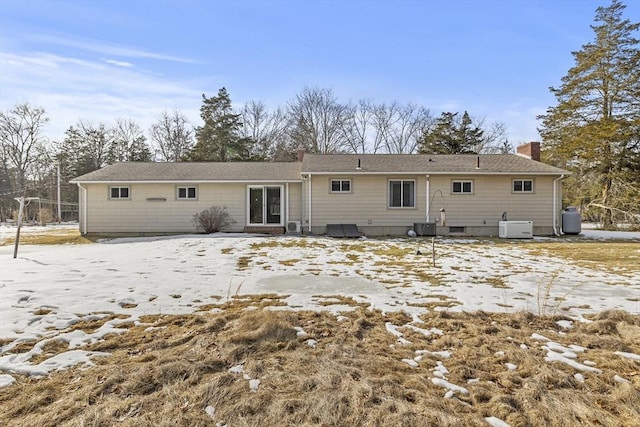 snow covered property with a chimney