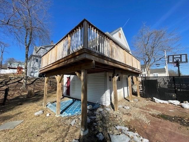 exterior space with a wooden deck, an attached garage, and fence