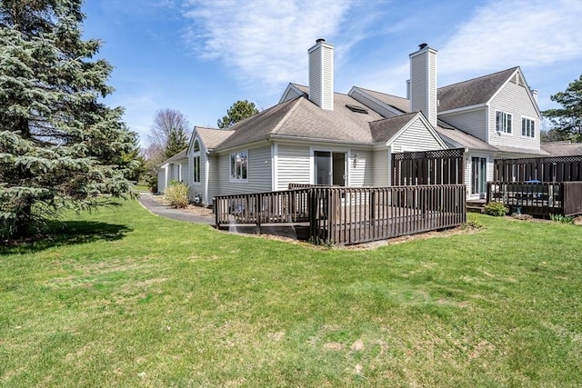 back of house with a lawn, a chimney, and a deck