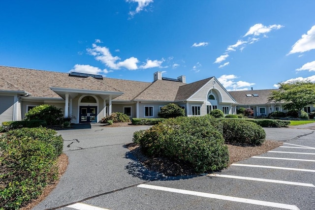 ranch-style house with uncovered parking, french doors, and a chimney