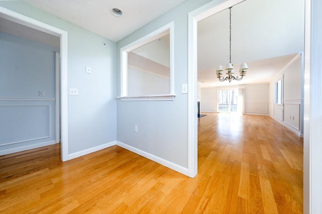 interior space with baseboards, a chandelier, and light wood-type flooring