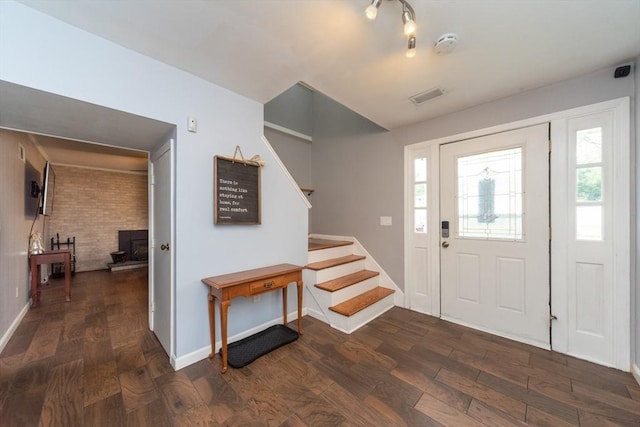 13 Westgate Rd, Framingham, MA 01701 - entrance foyer featuring stairway, dark wood-style flooring, and a wood stove
