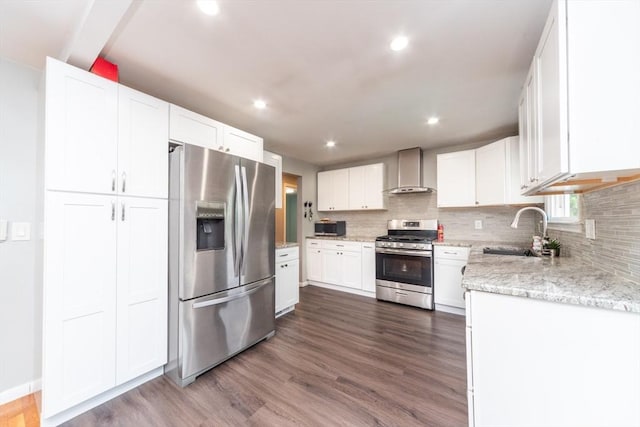 13 Westgate Rd, Framingham, MA 01701 - kitchen featuring appliances with stainless steel finishes, wall chimney range hood, tasteful backsplash, white cabinetry, and dark wood-style floors