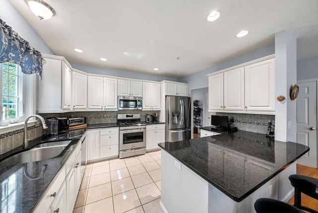 304 Godfrey Dr Unit 304, Norton, MA 02766 - kitchen with appliances with stainless steel finishes, a sink, decorative backsplash, white cabinets, and a kitchen bar