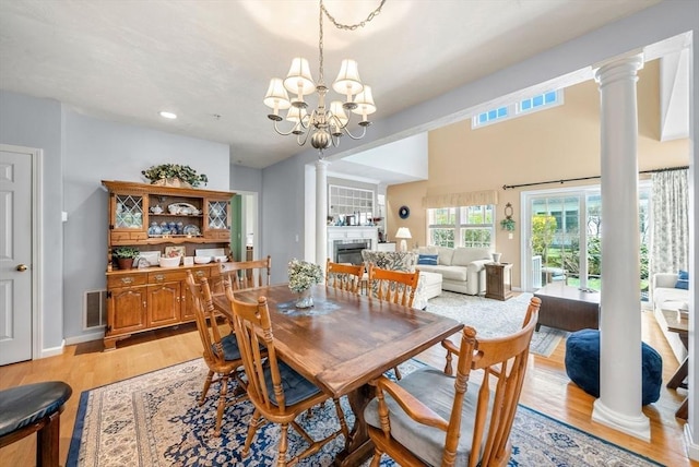 304 Godfrey Dr Unit 304, Norton, MA 02766 - dining space featuring a glass covered fireplace, light wood-style flooring, a chandelier, decorative columns, and recessed lighting