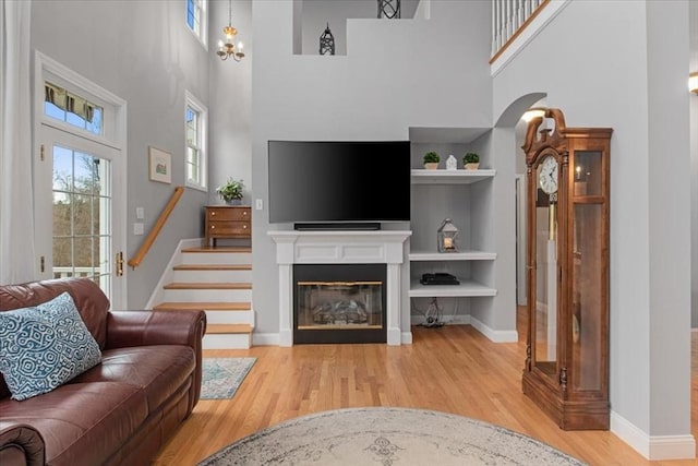 4 Rose Court Way Unit 4, Walpole, MA 02032 - living room with a towering ceiling, wood finished floors, baseboards, stairway, and a glass covered fireplace