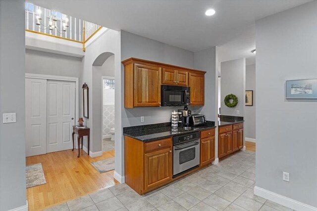 4 Rose Court Way Unit 4, Walpole, MA 02032 - kitchen featuring stainless steel oven, black microwave, arched walkways, brown cabinets, and baseboards