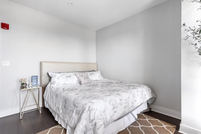 bedroom with dark hardwood / wood-style flooring