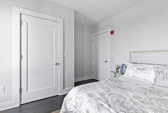 bedroom with dark hardwood / wood-style flooring and a closet