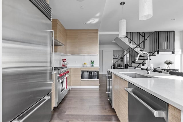 kitchen with sink, hanging light fixtures, light brown cabinets, beverage cooler, and high quality appliances