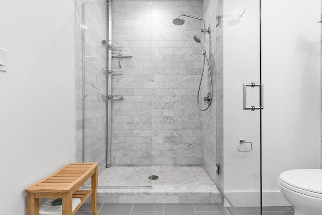 bathroom with tile patterned floors, a shower with door, and toilet