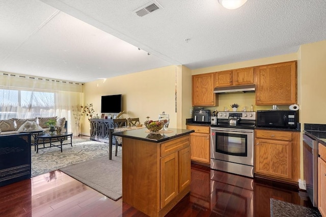 kitchen with a center island, a textured ceiling, stainless steel appliances, and dark hardwood / wood-style floors