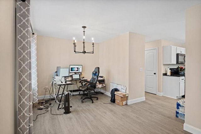 office space with baseboards, a chandelier, and light wood-style floors