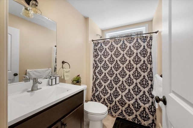 full bath with curtained shower, vanity, and toilet