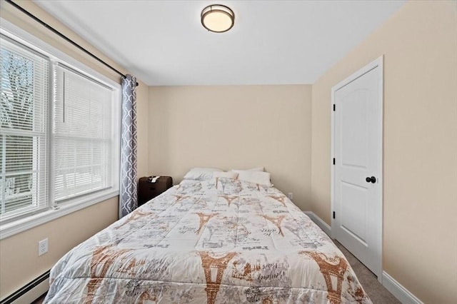 carpeted bedroom featuring baseboard heating and baseboards