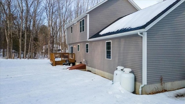 view of snow covered exterior featuring a wooden deck