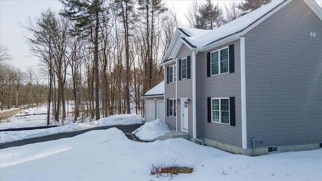 snow covered property featuring a garage