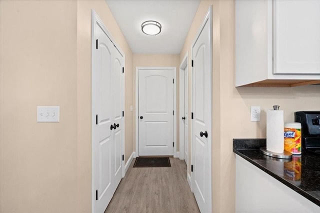 hall featuring wood finished floors and baseboards