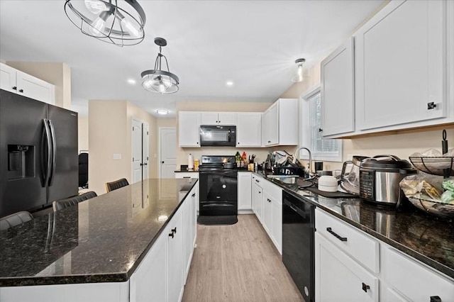 kitchen with light wood-style flooring, white cabinets, a kitchen island, a sink, and black appliances