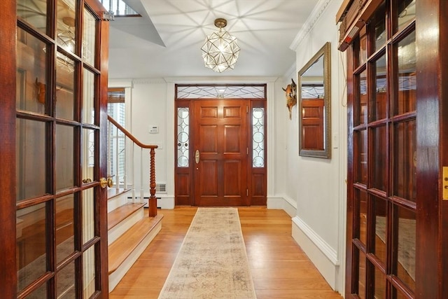 entryway with light wood-style floors, baseboards, and french doors