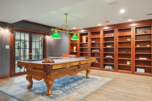 rec room with an inviting chandelier, ornamental molding, billiards, wood finished floors, and french doors