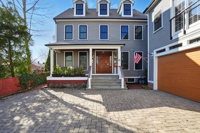 view of front of house with a garage, covered porch, and decorative driveway