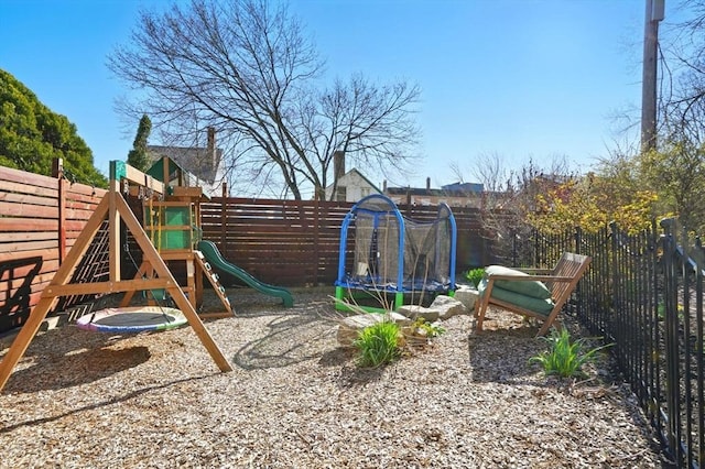 view of jungle gym with a trampoline and fence