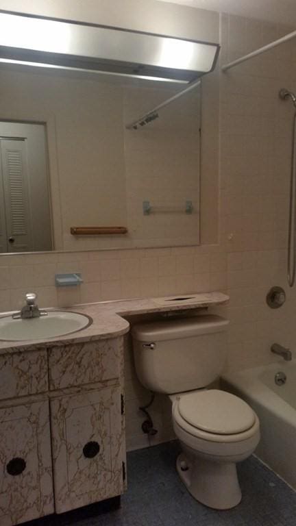 924 Main St Unit 23, Woburn, MA 01801 - bathroom featuring toilet, vanity, bathtub / shower combination, tile walls, and tile patterned floors