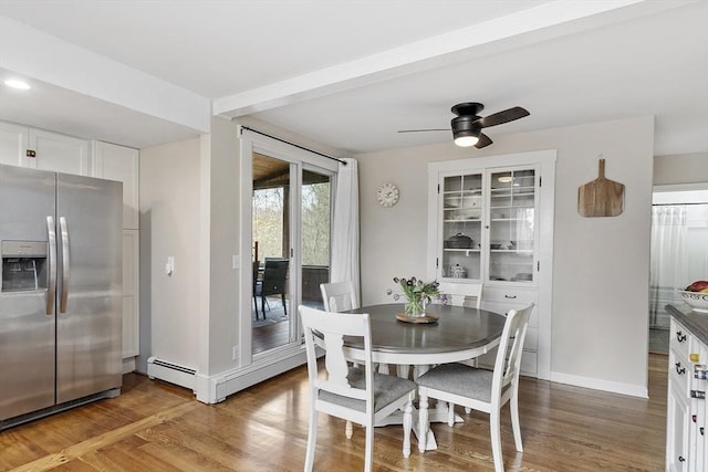 dining space featuring baseboards, ceiling fan, and wood finished floors