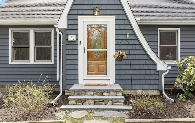 doorway to property featuring a shingled roof