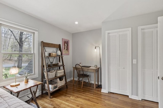 bedroom featuring baseboards, two closets, recessed lighting, and light wood-style flooring