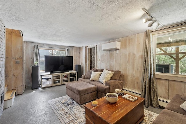 living area with a wall mounted air conditioner, a textured ceiling, a baseboard heating unit, and wood walls