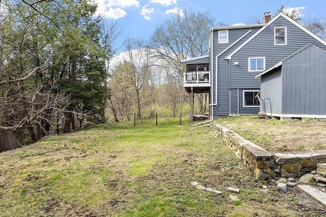 view of yard with a storage unit, an outdoor structure, and a balcony