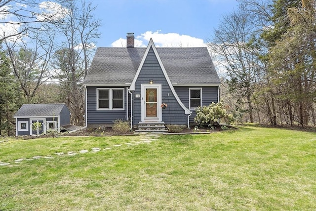 view of front of property featuring roof with shingles, a storage unit, a chimney, and a front yard