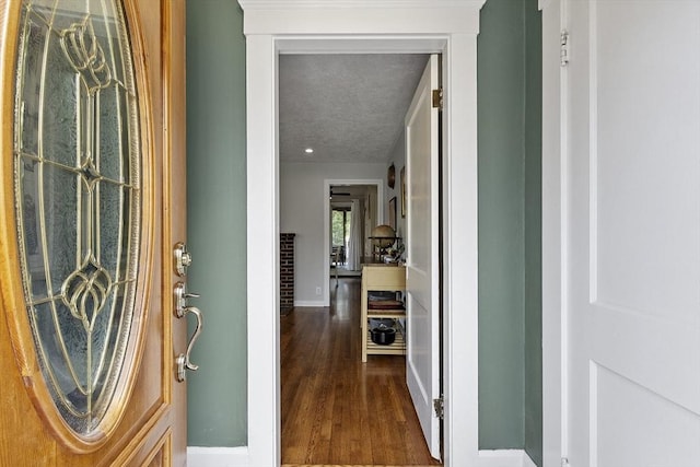 foyer featuring baseboards and wood finished floors