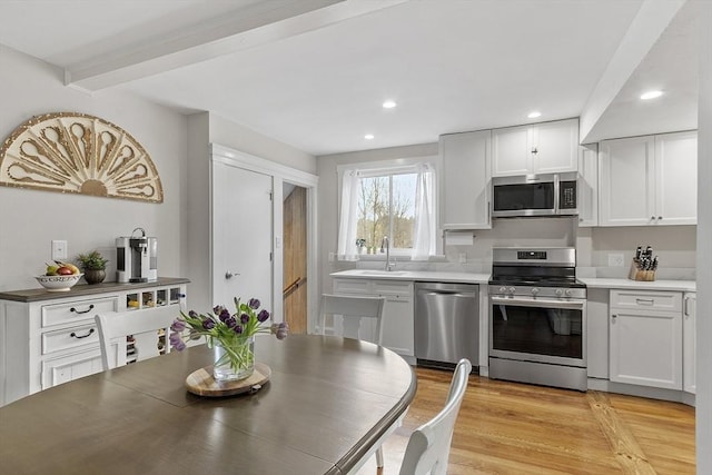 kitchen featuring white cabinets, stainless steel appliances, recessed lighting, and a sink