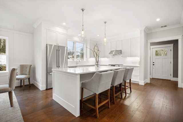 kitchen with a kitchen island with sink, white cabinetry, high quality fridge, and dark hardwood / wood-style flooring