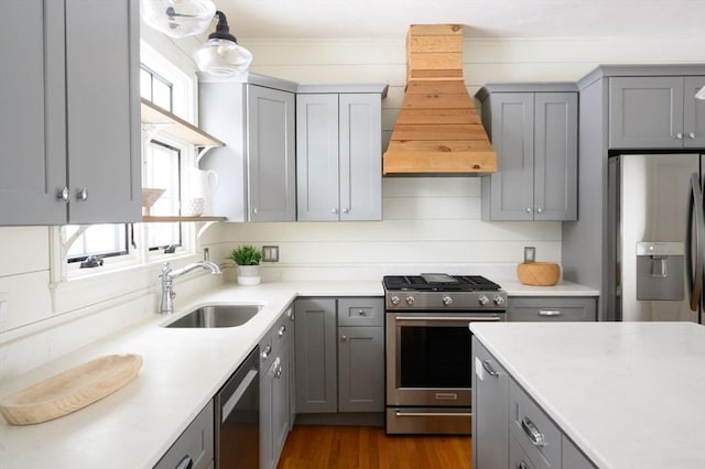 kitchen featuring appliances with stainless steel finishes, custom range hood, sink, and gray cabinetry