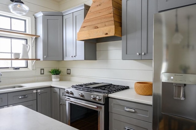 kitchen with gray cabinetry, sink, premium range hood, and appliances with stainless steel finishes