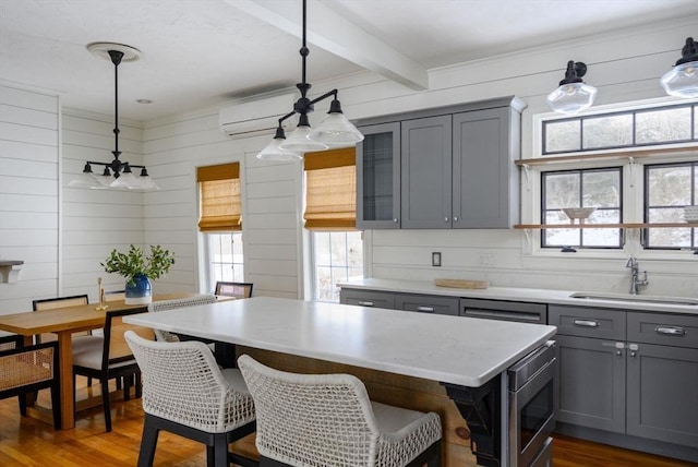 kitchen featuring pendant lighting, sink, dark wood-type flooring, and beamed ceiling