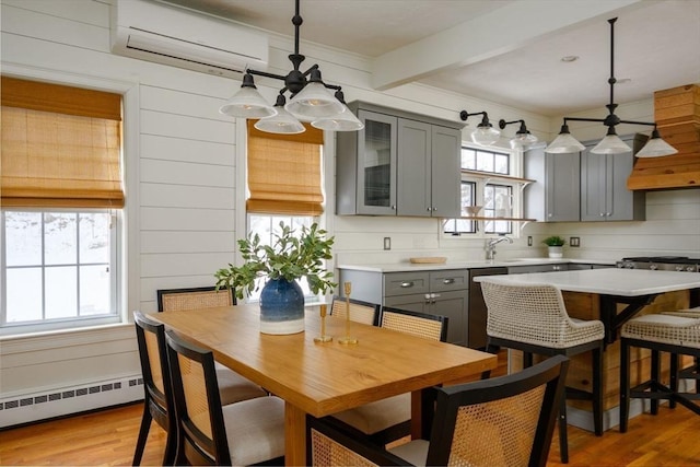 kitchen with pendant lighting, gray cabinetry, beamed ceiling, and appliances with stainless steel finishes