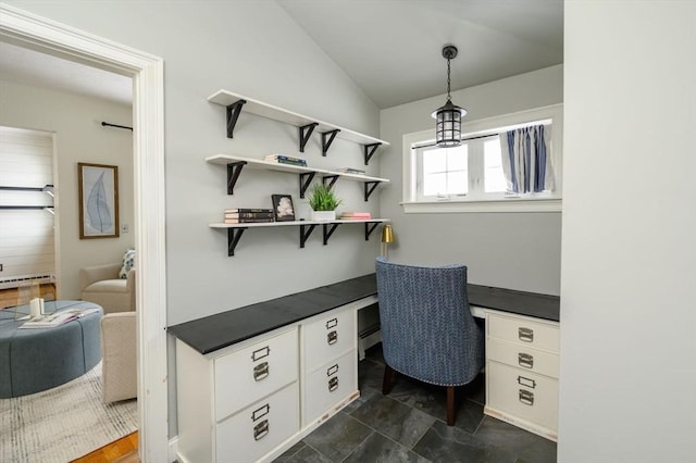 office space featuring lofted ceiling, a baseboard heating unit, and built in desk