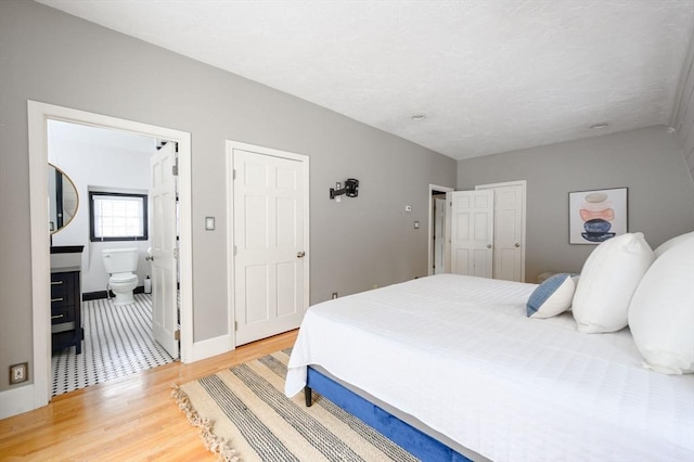 bedroom featuring hardwood / wood-style floors and connected bathroom