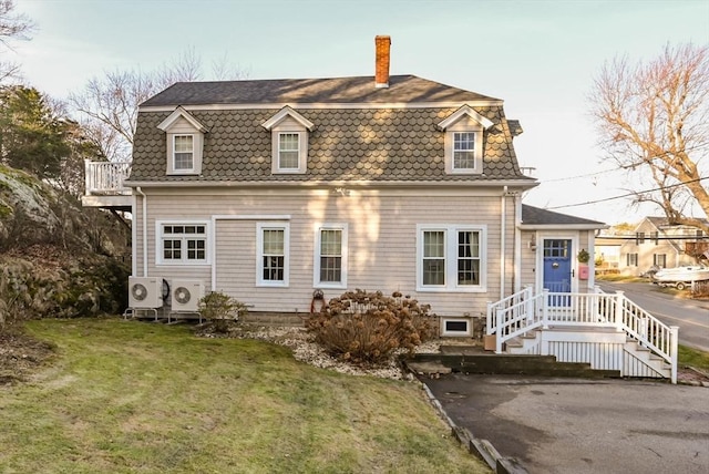 view of front of property featuring a front yard and ac unit