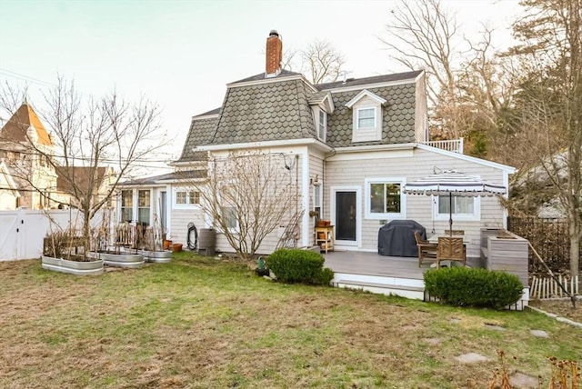 rear view of property featuring a wooden deck and a yard