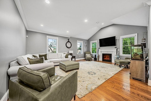 living room with lofted ceiling, a high end fireplace, recessed lighting, baseboards, and light wood-style floors