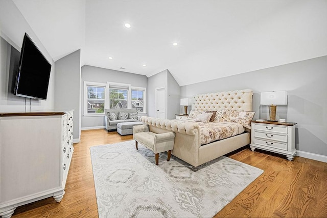 bedroom featuring baseboards, light wood-style flooring, and vaulted ceiling
