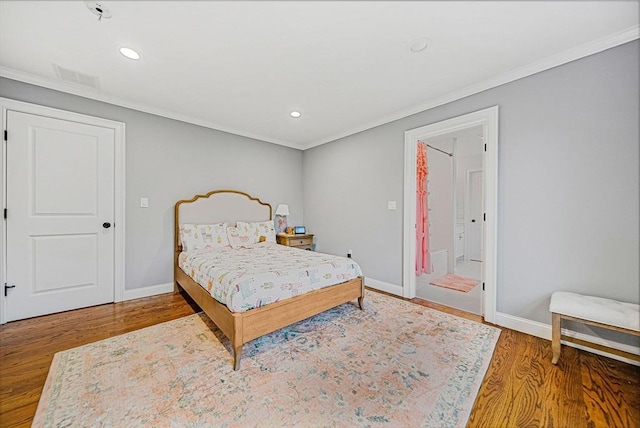 bedroom with baseboards, visible vents, crown molding, and wood finished floors