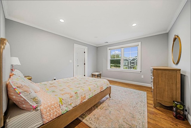 bedroom with crown molding, wood finished floors, baseboards, and recessed lighting
