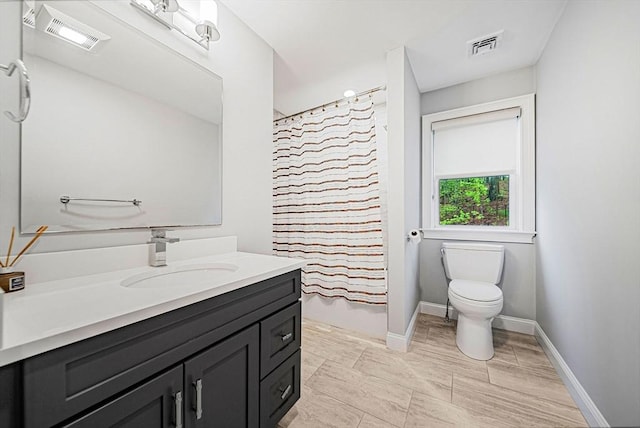bathroom featuring toilet, visible vents, baseboards, and vanity